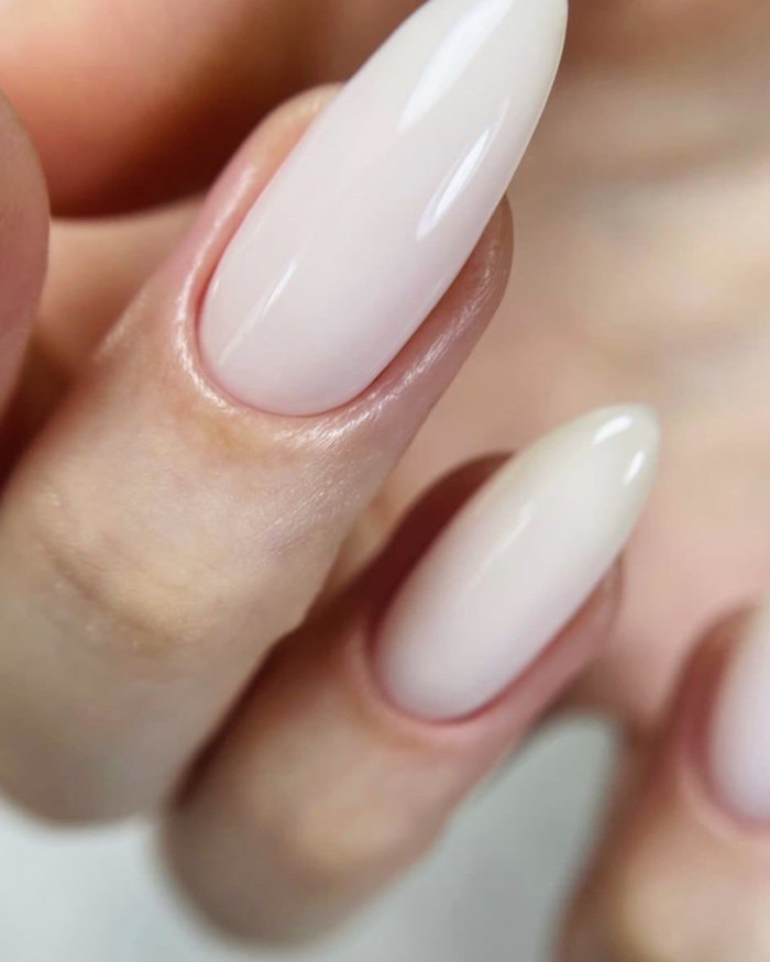 Glossy milky-pink gel on almond nails