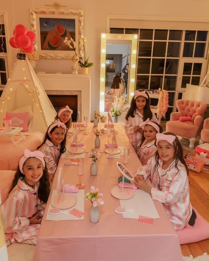 Girls at a long pink spa table